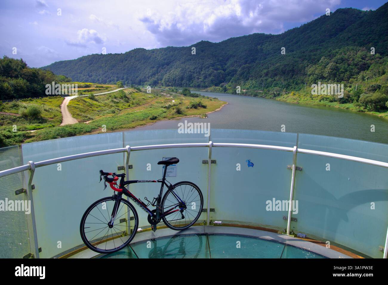 Sunchang County, South Korea - October 4, 2021: A road bike rests on the glass-bottom Skywalk of Hyangga Bridge, overlooking the Seomjin River and the Stock Photo