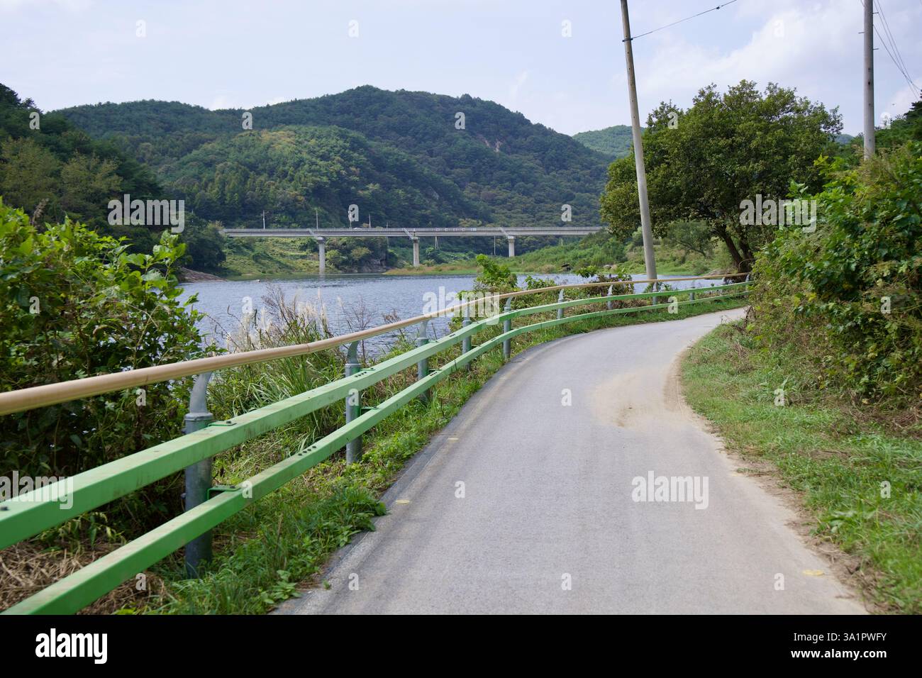 Sunchang County, South Korea - October 4, 2021: A winding section of the Seomjingang Bike Path follows the Seomjin River, with a bridge in the distanc Stock Photo