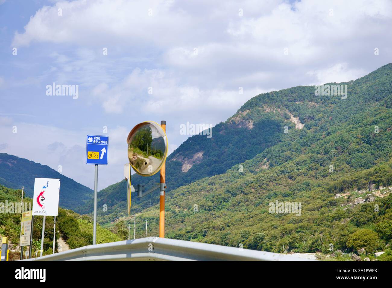 Sunchang County, South Korea - October 4, 2021: A Seomjingang Bike Path sign marks the cycling route toward Chungju, with a convex traffic mirror refl Stock Photo