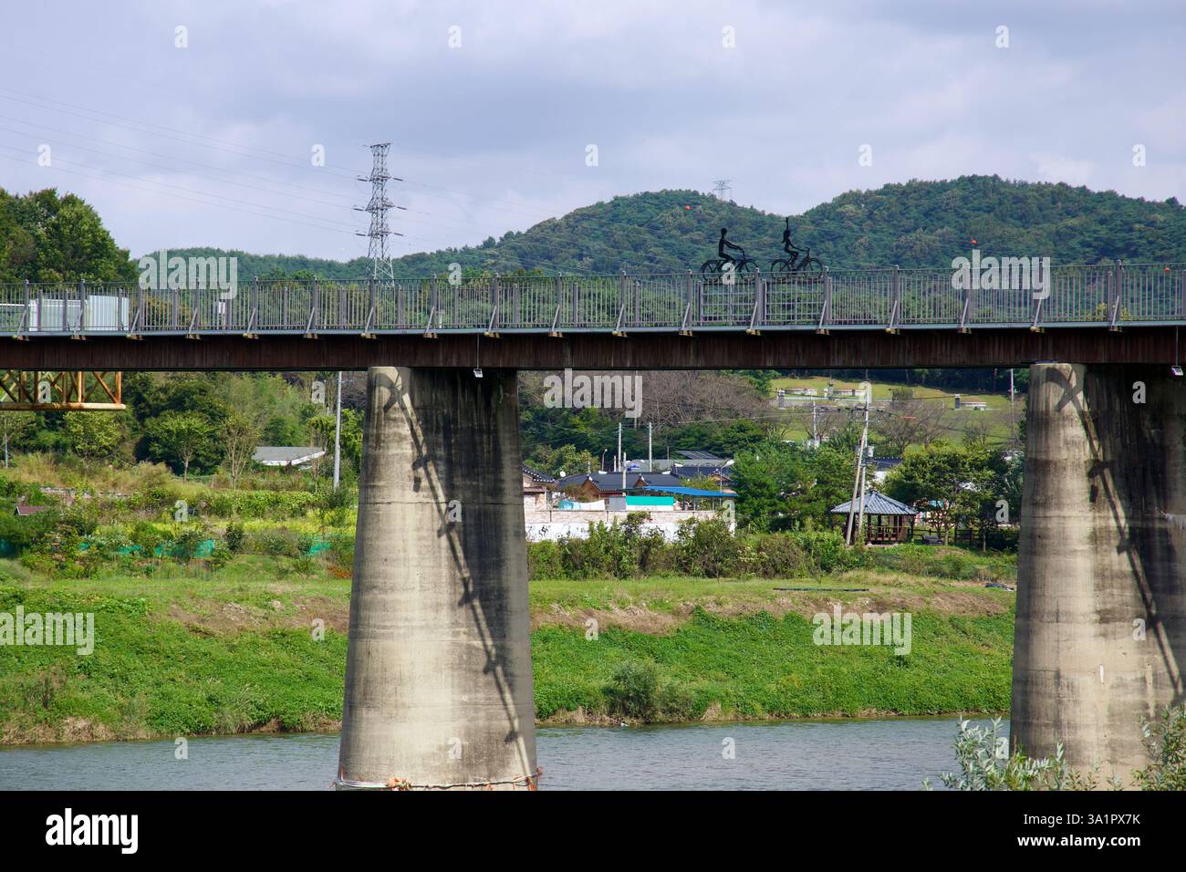Sunchang County, South Korea - October 4, 2021: Metal sculptures of cyclists stand atop Hyangga Bridge, a former railway structure now repurposed for Stock Photo