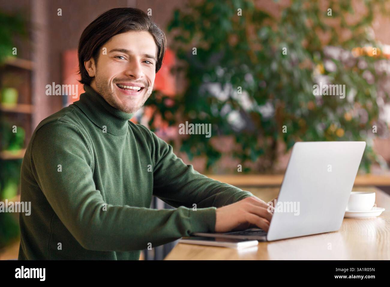 Cheerful programmer working at cafe, enjoying his job Stock Photo