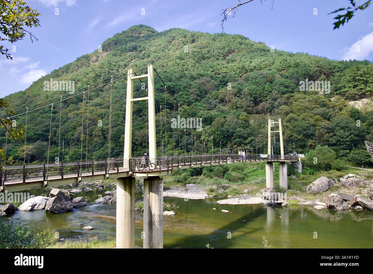Sunchang County, South Korea - October 4, 2021: The Janggunmok Suspension Bridge stretches over the Seomjin River, set against a lush, forested mounta Stock Photo