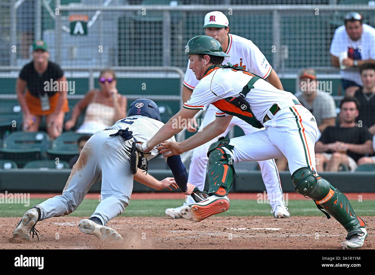CORAL GABLES, FL - MARCH 09: Miami catcher Nolan Johnson (21) tags ...