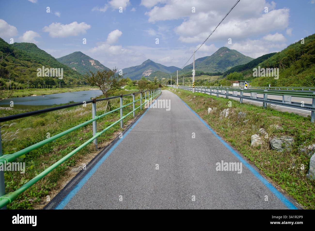 Sunchang County, South Korea - October 4, 2021: A well-maintained section of the Seomjingang Bike Path follows the Seomjin River, with green railings Stock Photo