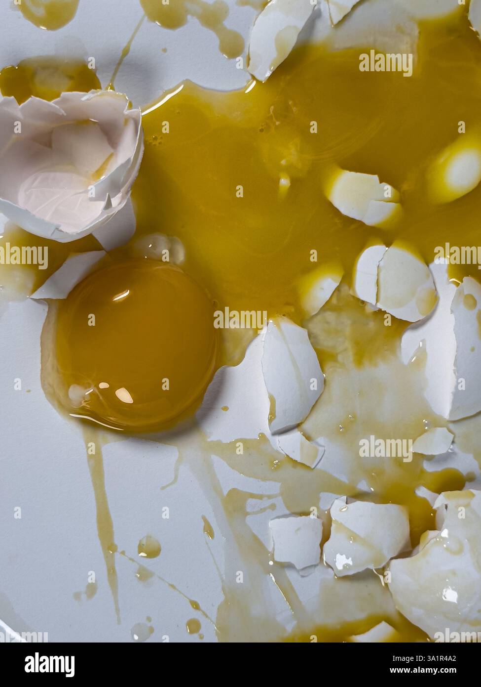 Messy cracked eggs on white background create abstract background plate. Stock Photo