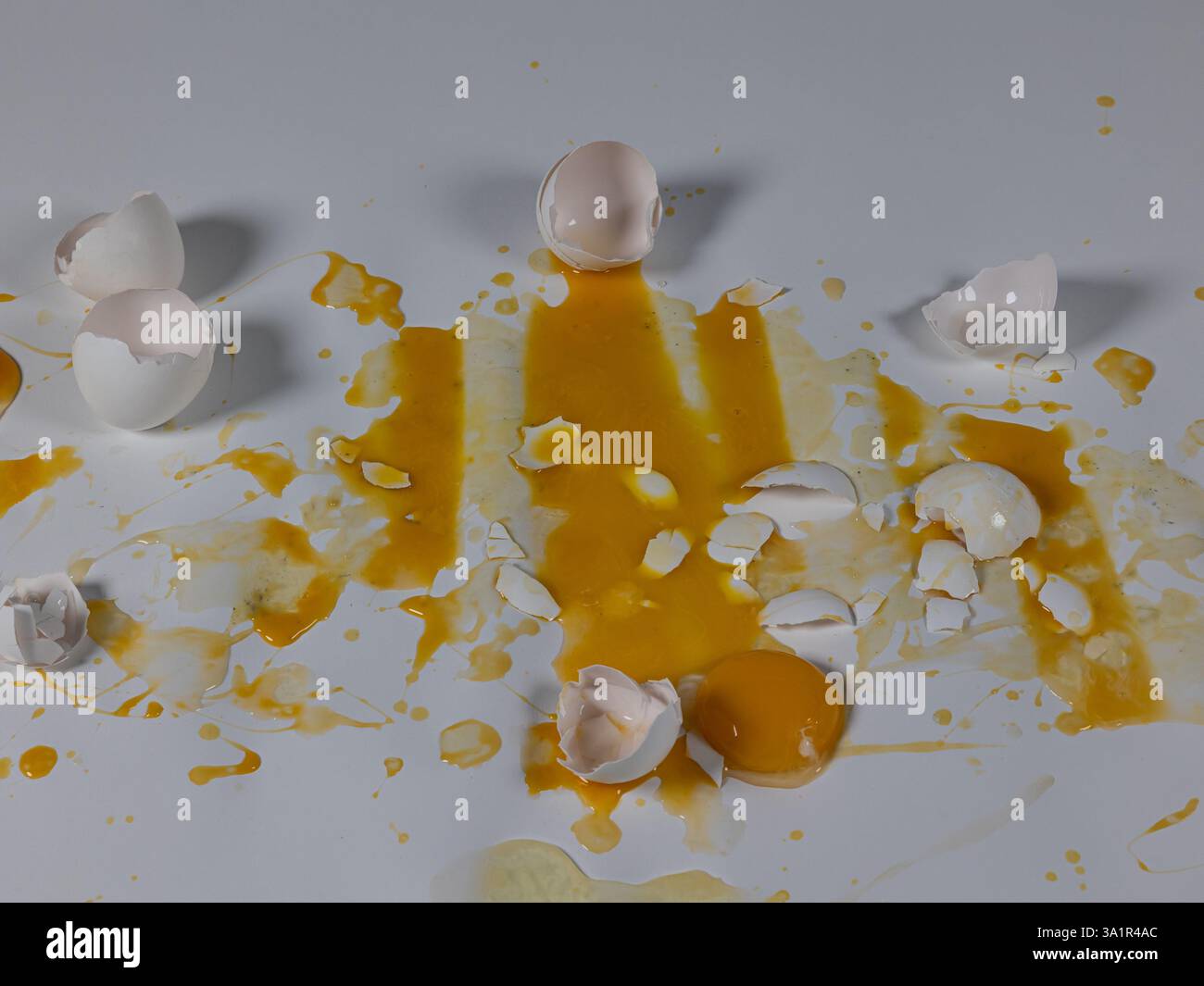 Messy cracked eggs on white background create abstract background plate. Stock Photo