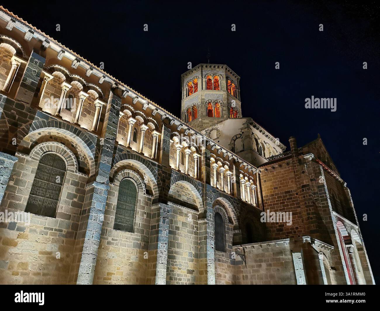 Issoire. Illuminated at night, the Abbatiale Saint Austremoine showcases its impressive Romanesque architecture. Puy de Dome. Auvergne. France - Smartphone Captured Stock Image