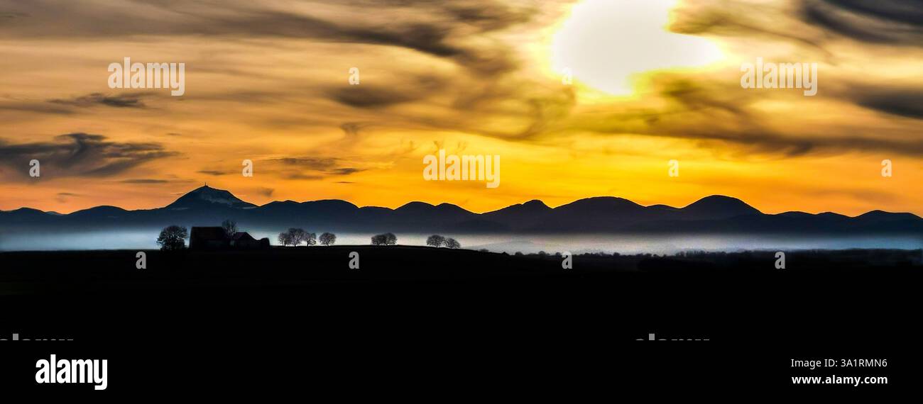 View of the Chain of Volcanoes and Limagne plain under a sunset sky in Puy-de-Dôme, Auvergne-Rhône-Alpes, France - Smartphone Captured Stock Image