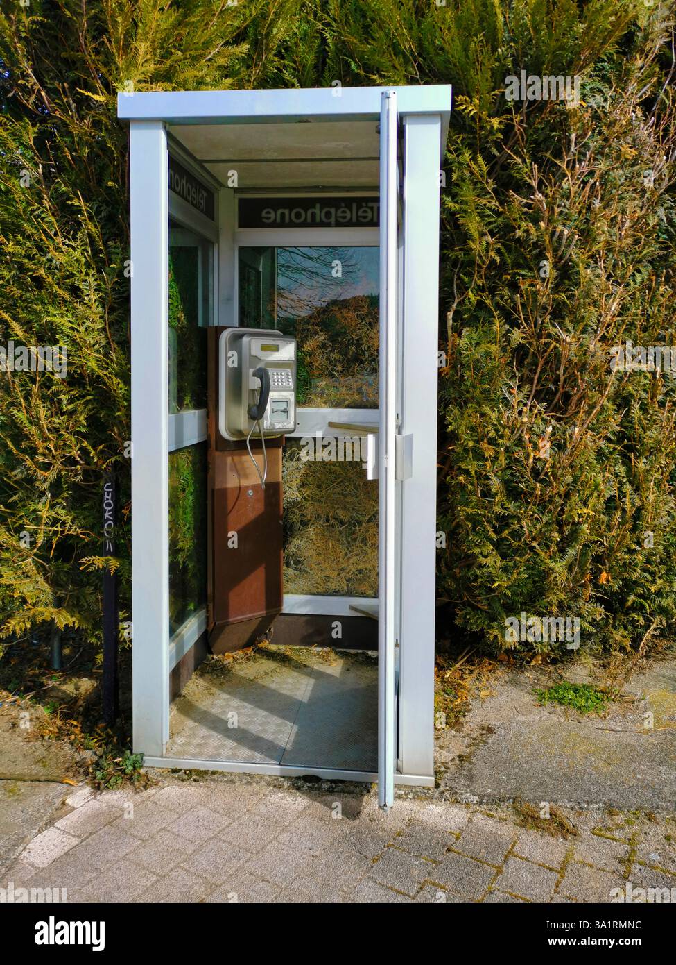 Nestled in the countryside, a weathered telephone box offers a glimpse ...