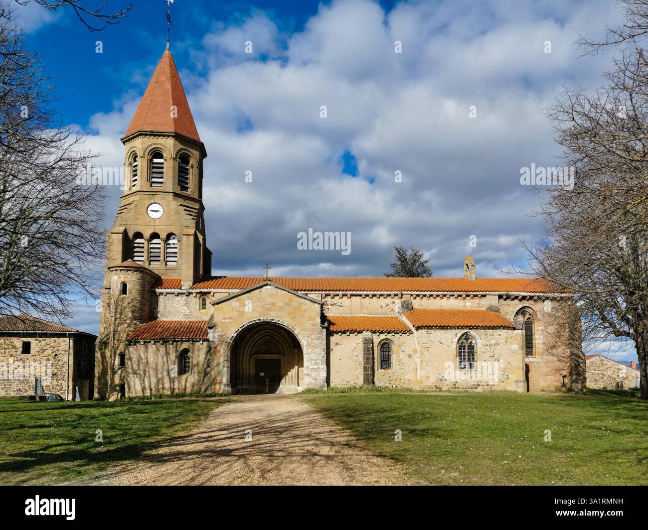 The Church Saint-Nicolas of Nonette showcases against a backdrop of fluffy clouds and expansive blue sky. Puy de Dome. Auvergne-Rhone-Alpes. France - Smartphone Captured Stock Image