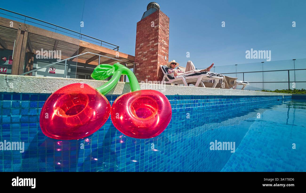 Inflatable cherries floating in swimming pool during summer vacation ...