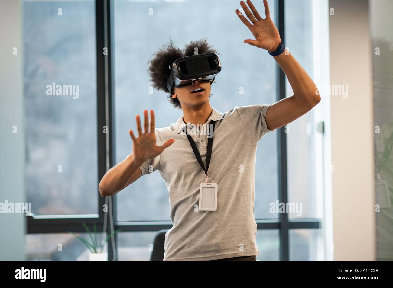 Man with Afro hairstyle using vr headset interacting with virtual environment Stock Photo