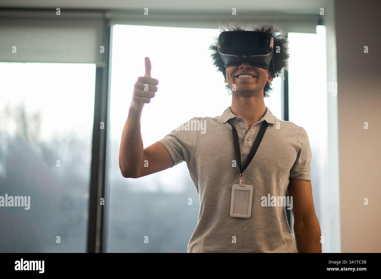 Man with Afro hairstyle using vr headset interacting with virtual environment Stock Photo