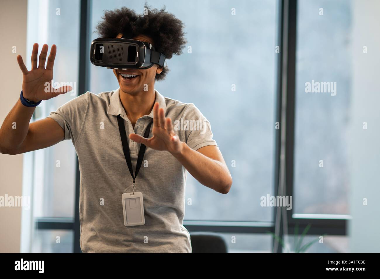 Man with Afro hairstyle using vr headset interacting with virtual environment Stock Photo