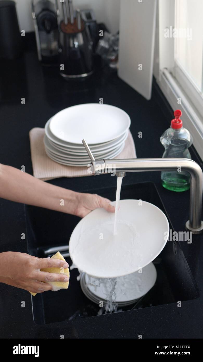 Rinsing Process Washing and rinsing dishes by hand under a stream of water in the ...