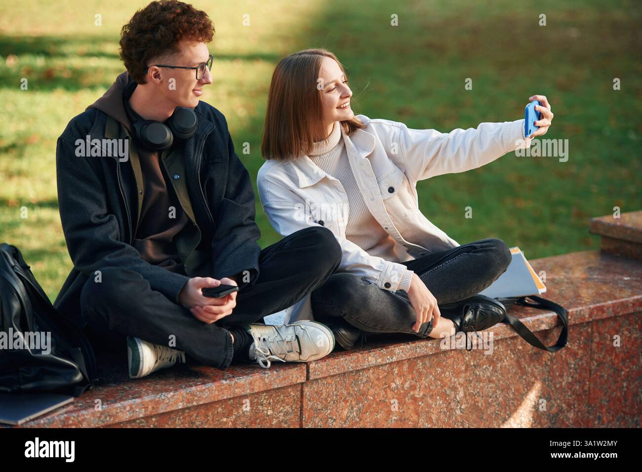Taking a selfie. Two young students are together outdoors. Stock Photo