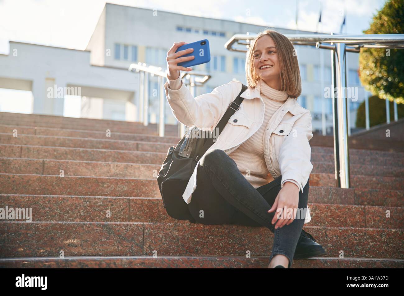 Making a selfie with smartphone. Young female student in casual clothes ...