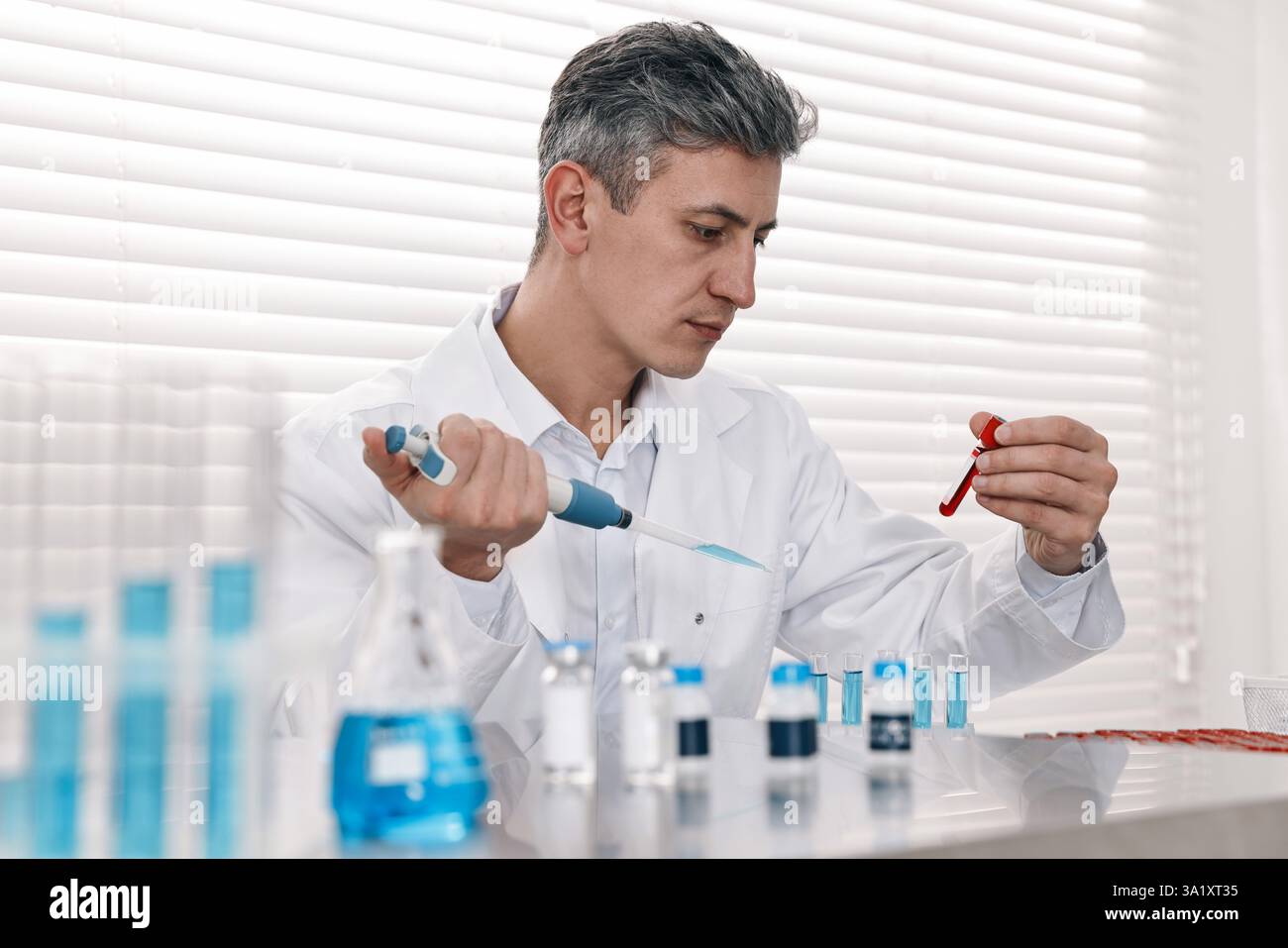 Scientist with micropipette and test tubes working in laboratory Stock ...