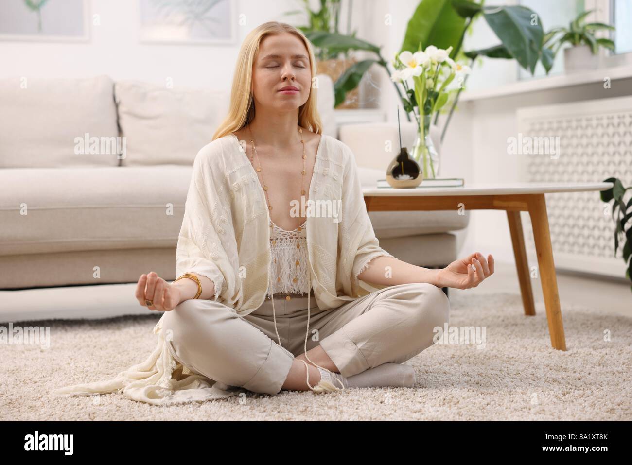 Feng shui. Young woman meditating on floor at home Stock Photo - Alamy