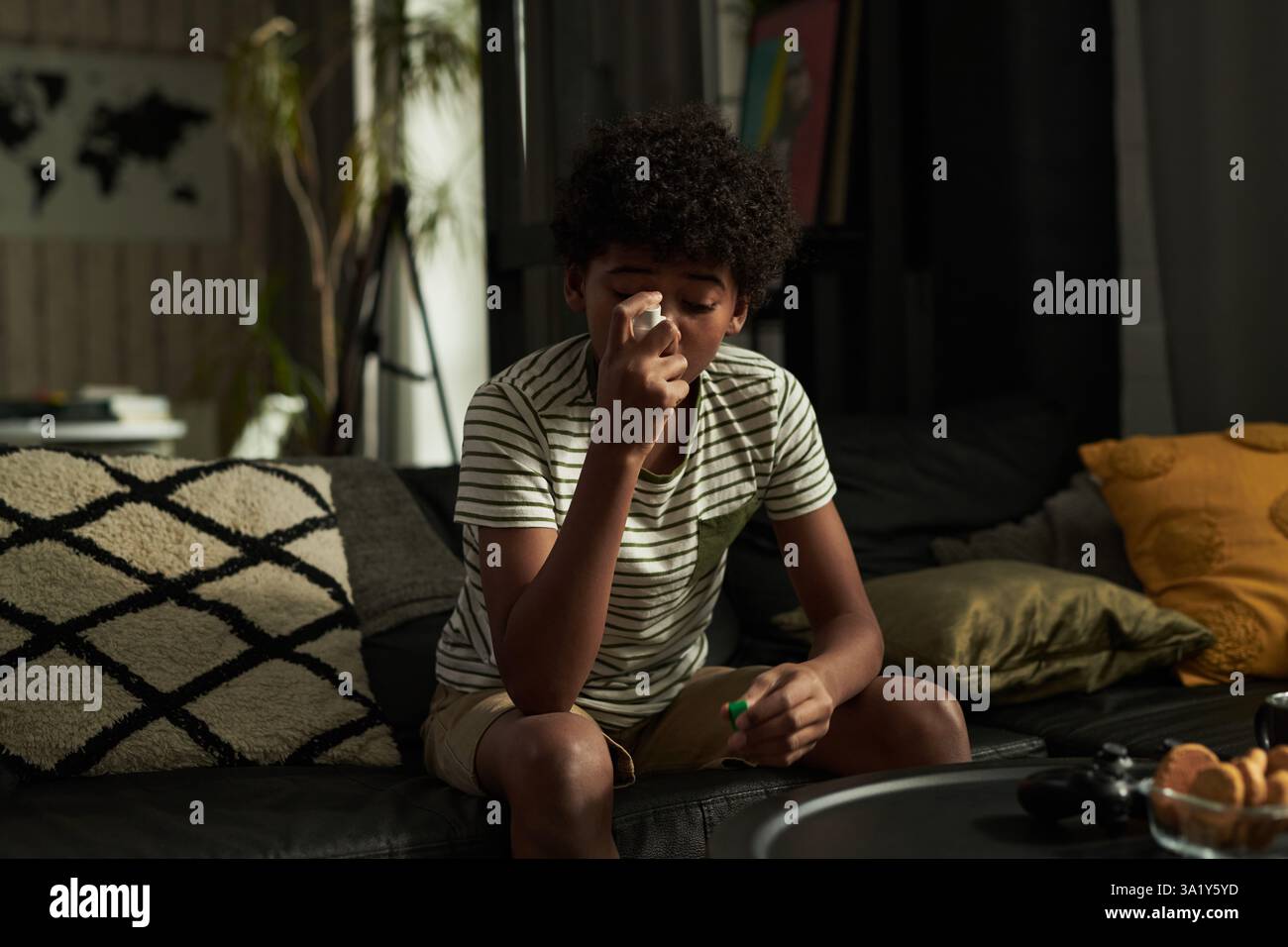 African American child with asthma pumping inhaler in mouth while ...
