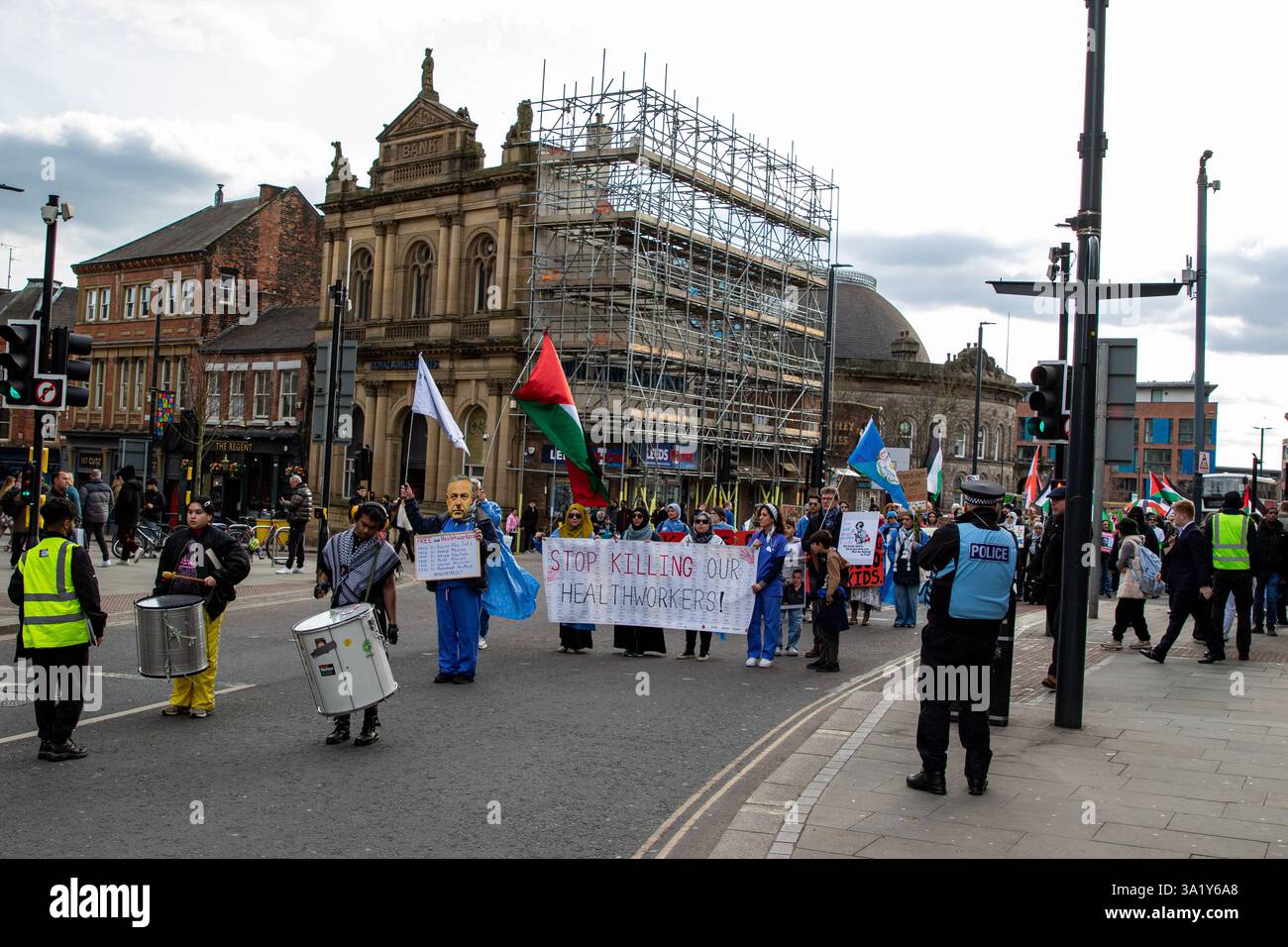 A street protest features a diverse group of people holding signs and ...