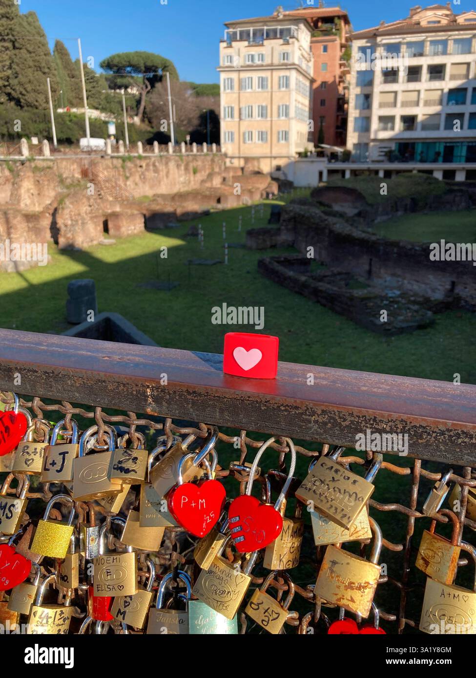 Italy, Lazio, Rome, Piazza Colosseo Square,  Padlock with Heart Shape attached to Fence Ruins of Ludus Magnus - Smartphone Captured Stock Image