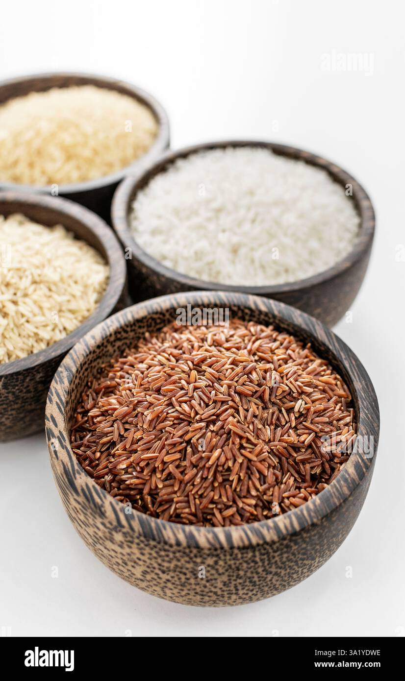 different kinds of asian rice grains in bowls on white background in ...