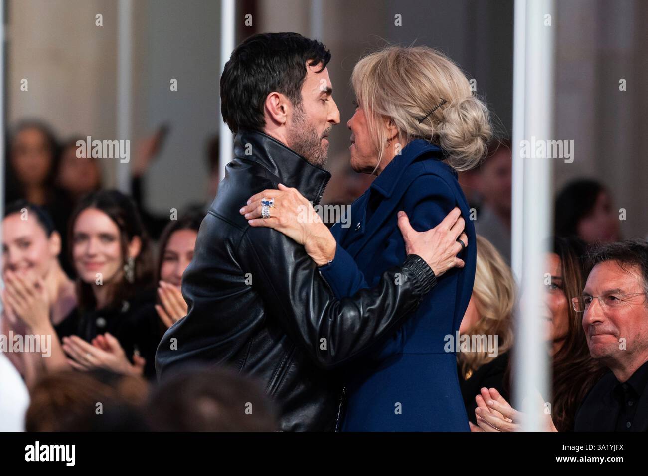 Designer Nicolas Ghesquiere, left, is congratulated by Brigitte Macron, following the Louis