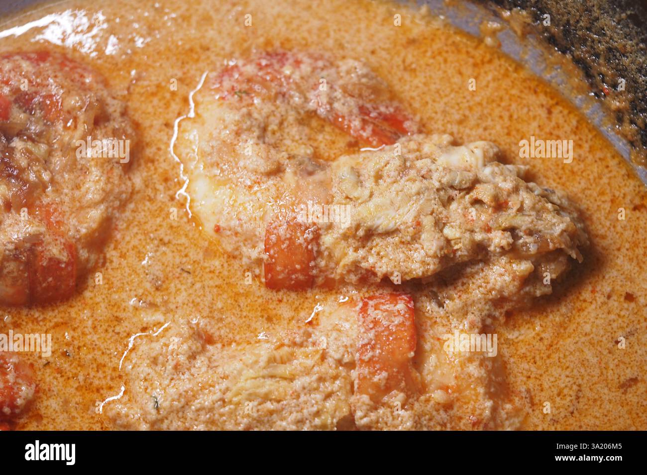Creamy seafood dish simmering in a rich sauce on stove Stock Photo - Alamy