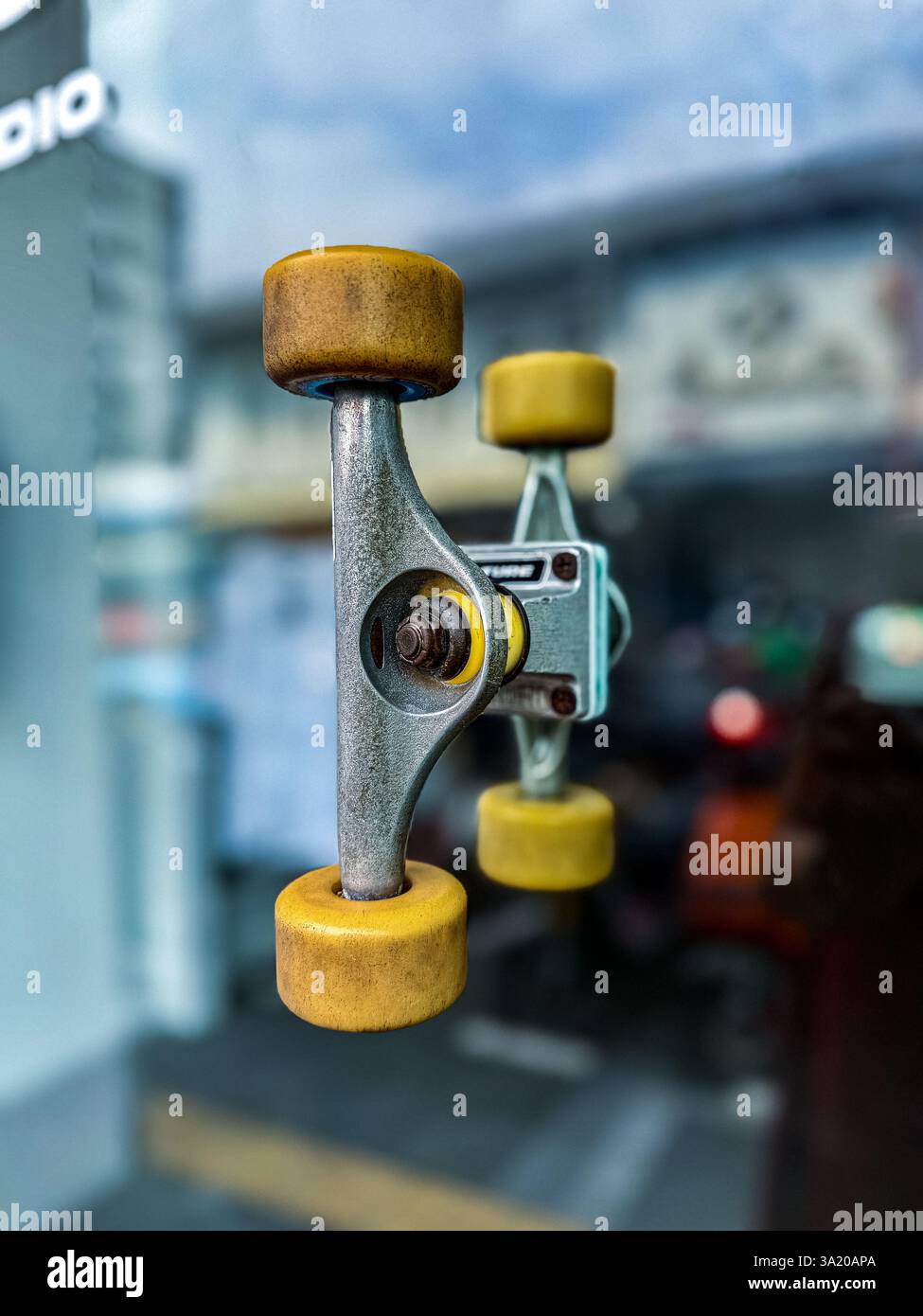 Unique door handle made from skateboard wheels A creative door handle designed using a skateboard truck and wheels, mounted on a glass door. The innov - Smartphone Captured Stock Image