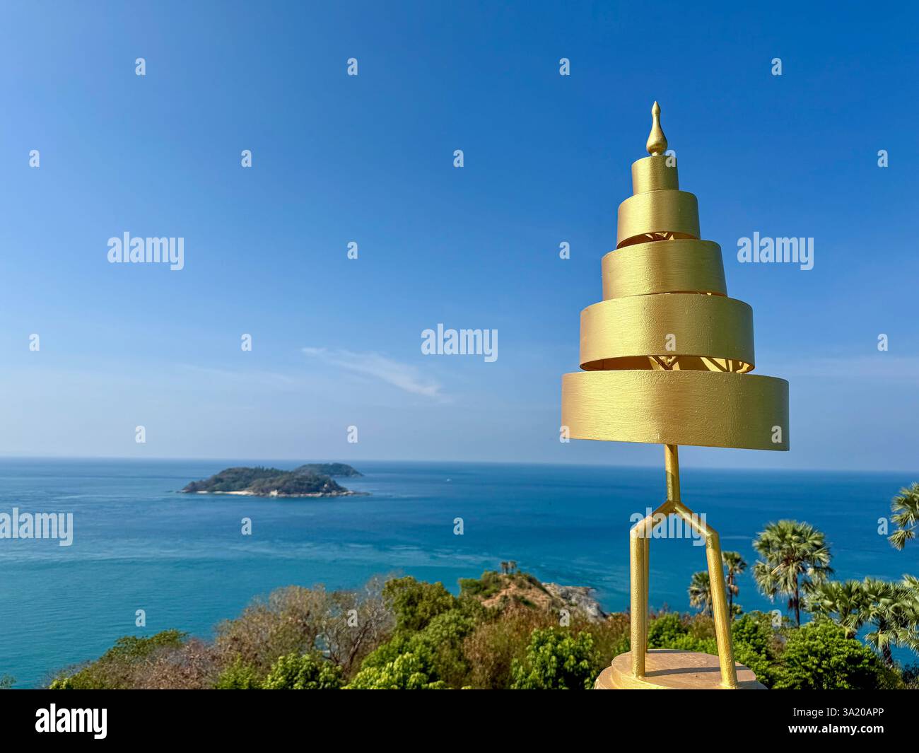 Golden Spiral Pagoda Overlooking the Sea 2 A golden spiral-shaped pagoda stands against a deep blue sky with a panoramic ocean view in the background. - Smartphone Captured Stock Image