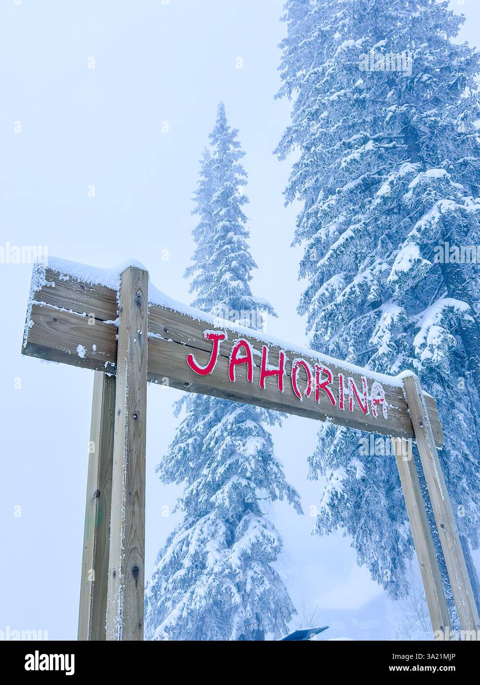 A rustic wooden sign proudly displays the name of the Olympic Mountain Jahorina, blending with the natural beauty of the snowy landscape. - Smartphone Captured Stock Image