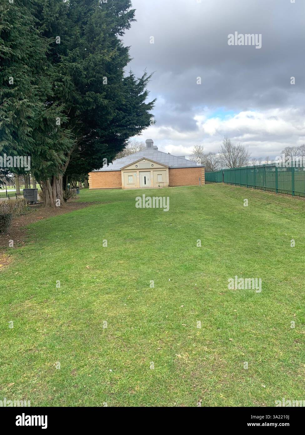 Northampton Northamptonshire England UK British park town Racecourse cat white grass friendly place rundown old path tree trees building - Smartphone Captured Stock Image