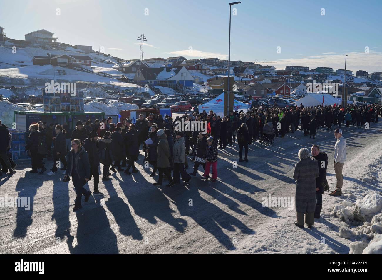 People stand in line outside a polling station to cast their vote in ...