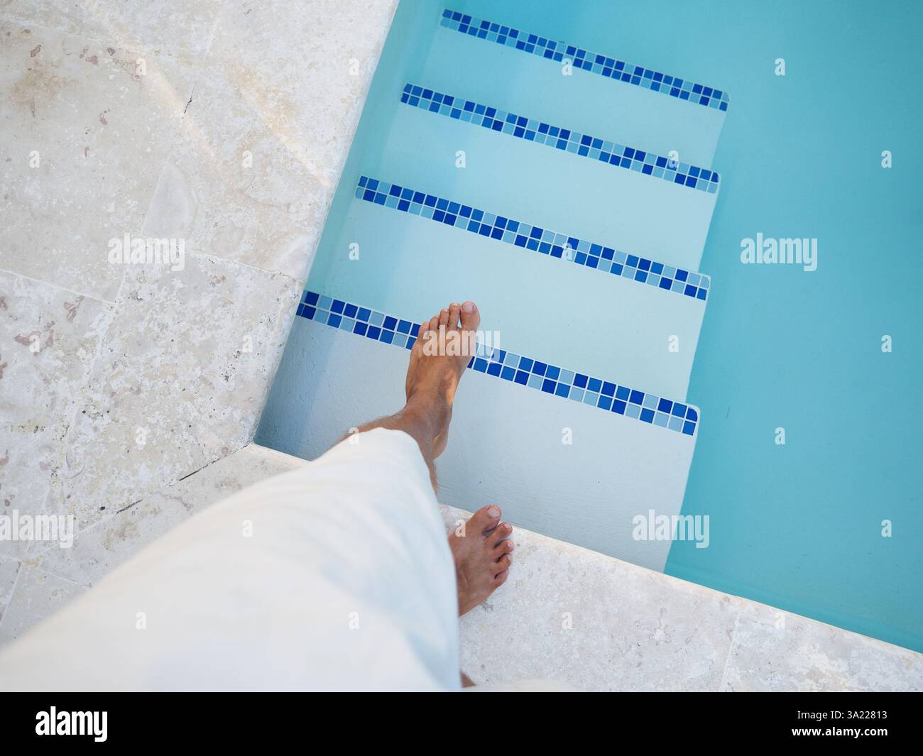 Person is preparing to step into a clear blue swimming pool. POV Stock ...