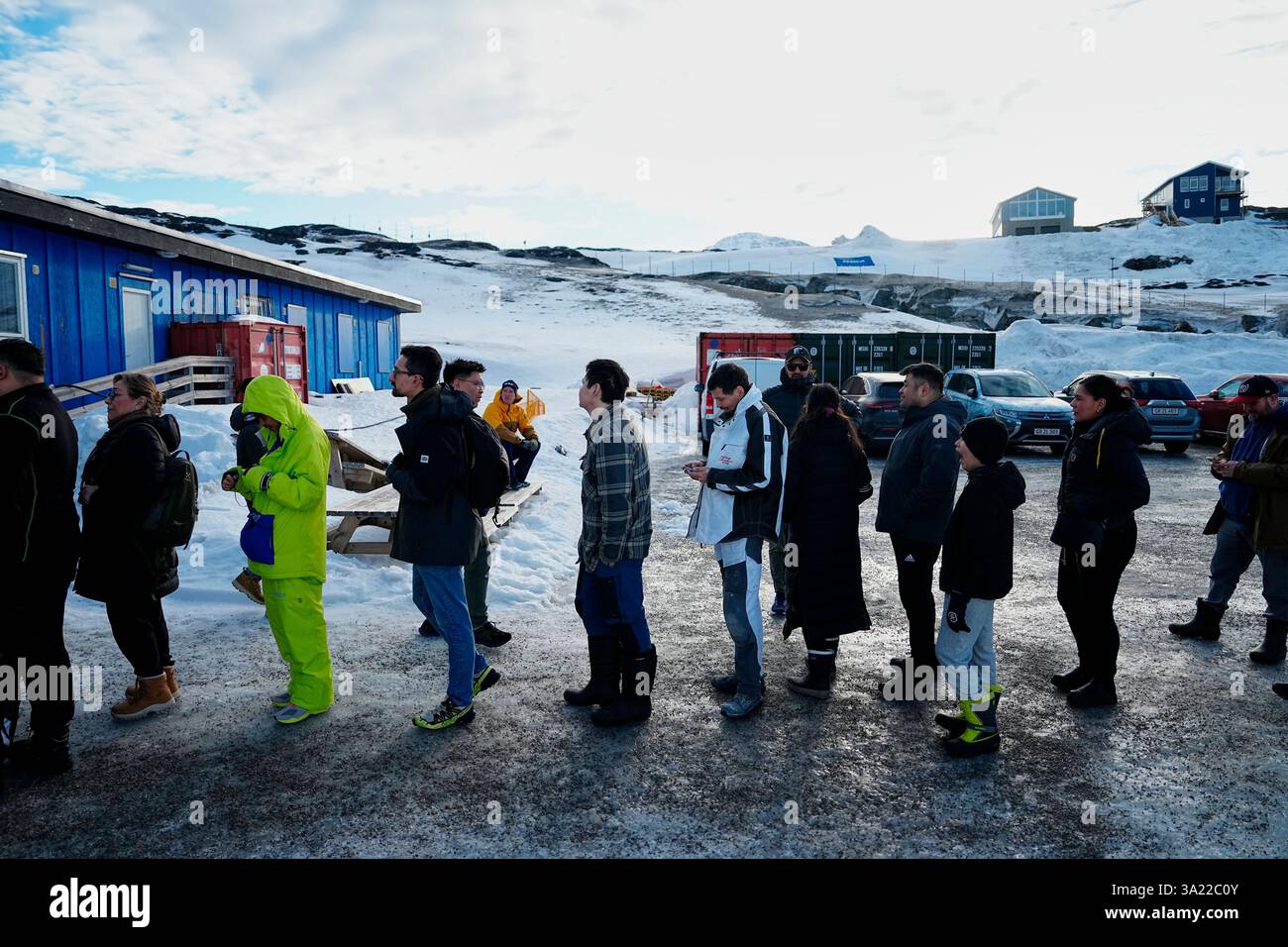 People queue outside a polling station to cast their vote in ...