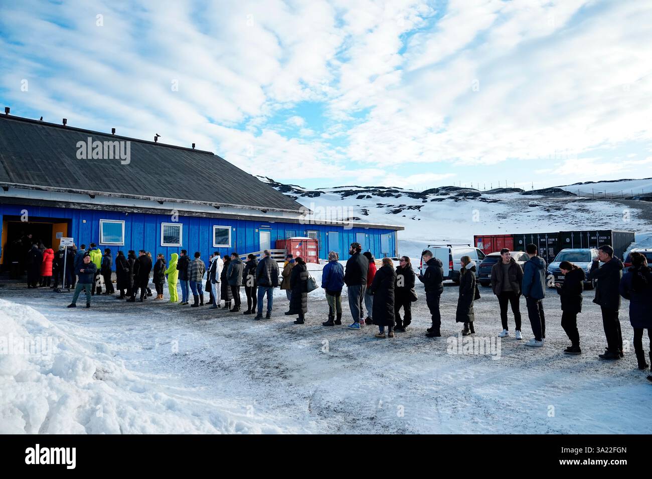 People queue outside a polling station to cast their vote in ...