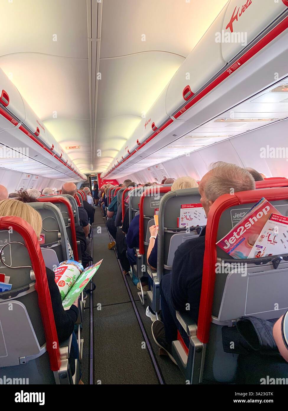 Jet 2 in flight trolley airliner passengers passenger staff working sell selling goods tea beer drink food Birmingham Police Policeman waiting sit sat - Smartphone Captured Stock Image