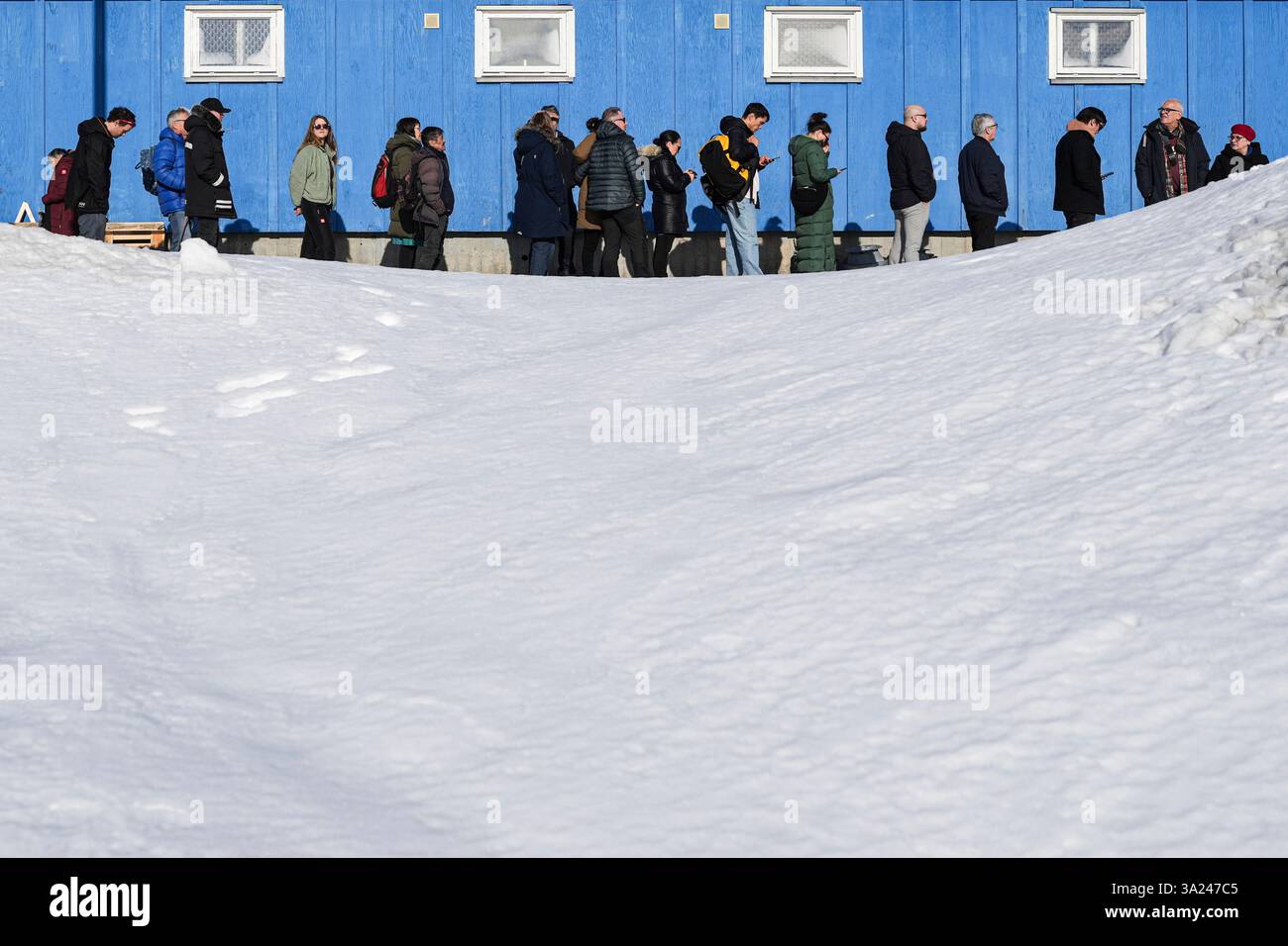 People stand in line outside a polling station to cast their vote in ...