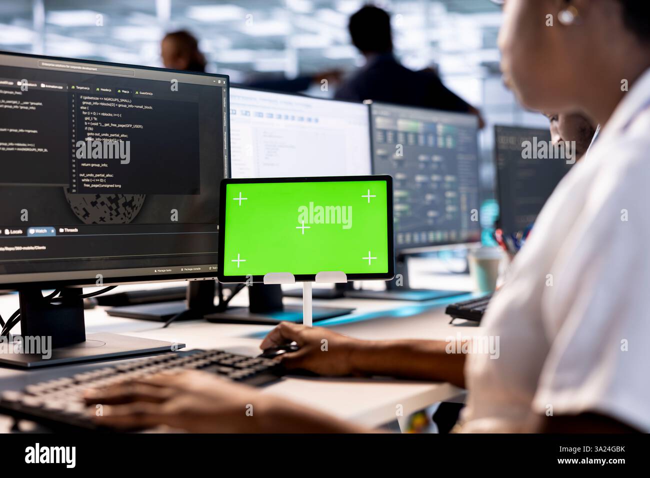 Computer scientist in data center updates rigs systems on green screen tablet to protect servers from exploitable software vulnerabilities. System administrator using mockup device to look for errors Stock Photo