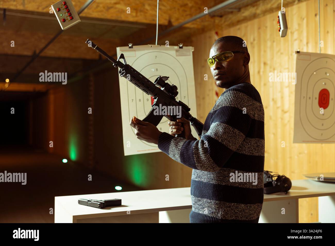 Portrait of shooting range client reloading rifle, preparing to shoot ...