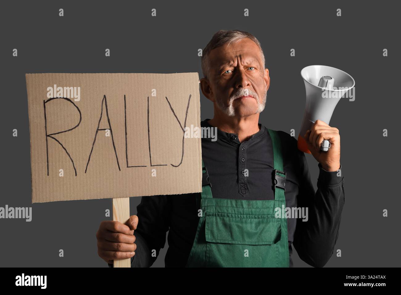 Protesting miner man with placard and megaphone on dark background Stock Photo