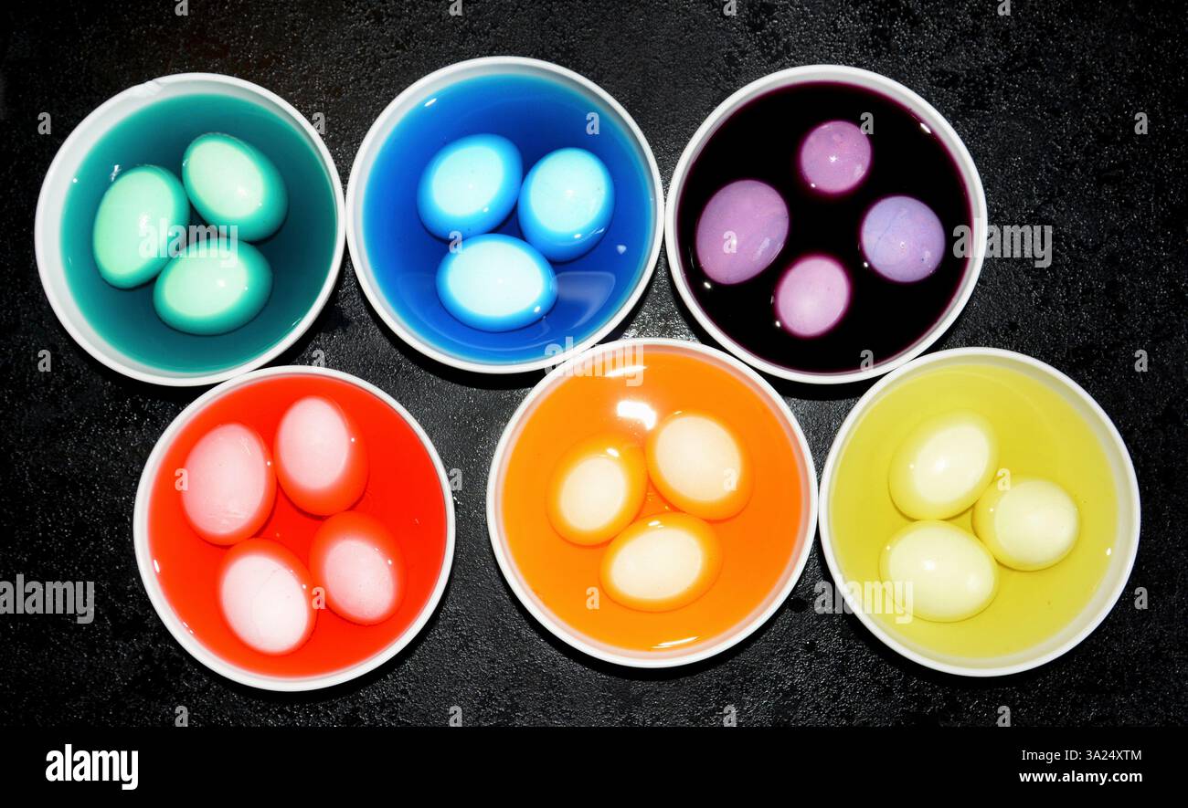 Dyeing different coloured Easter eggs Stock Photo