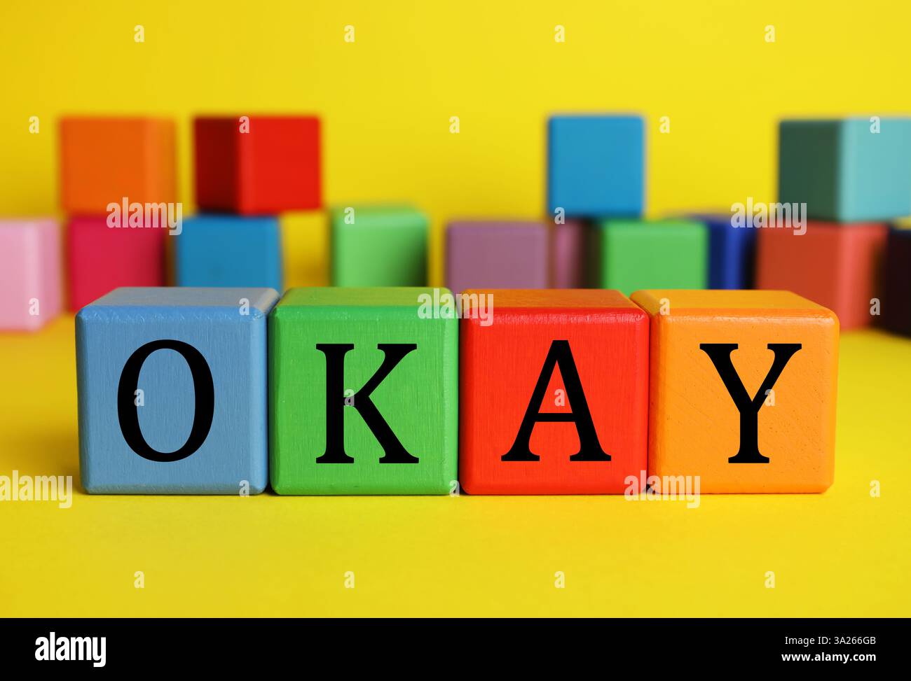 Colorful cubes with word Okay on yellow background Stock Photo