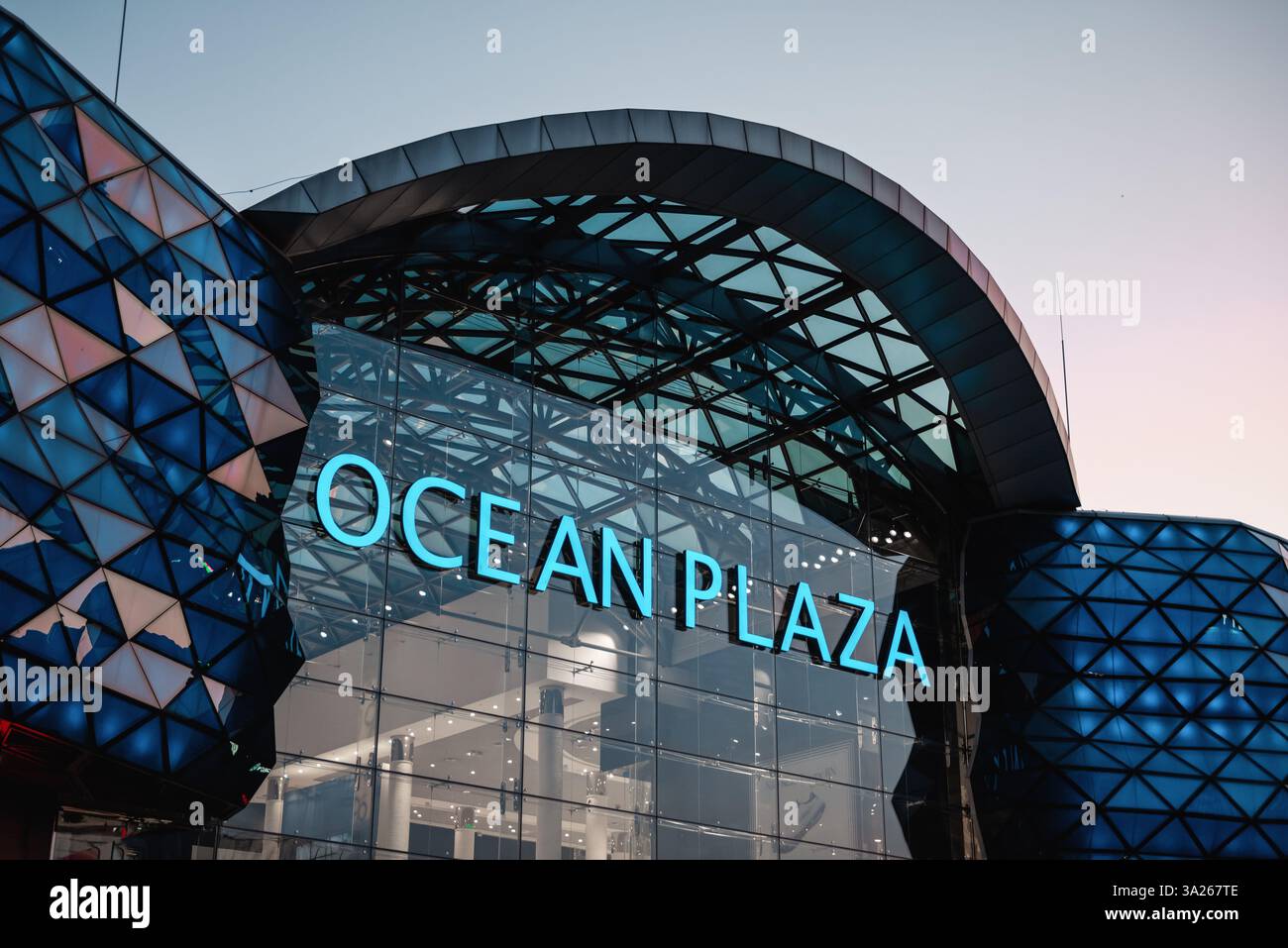 Ocean Plaza shopping mall at sunset. Illuminated glass facade of modern ...