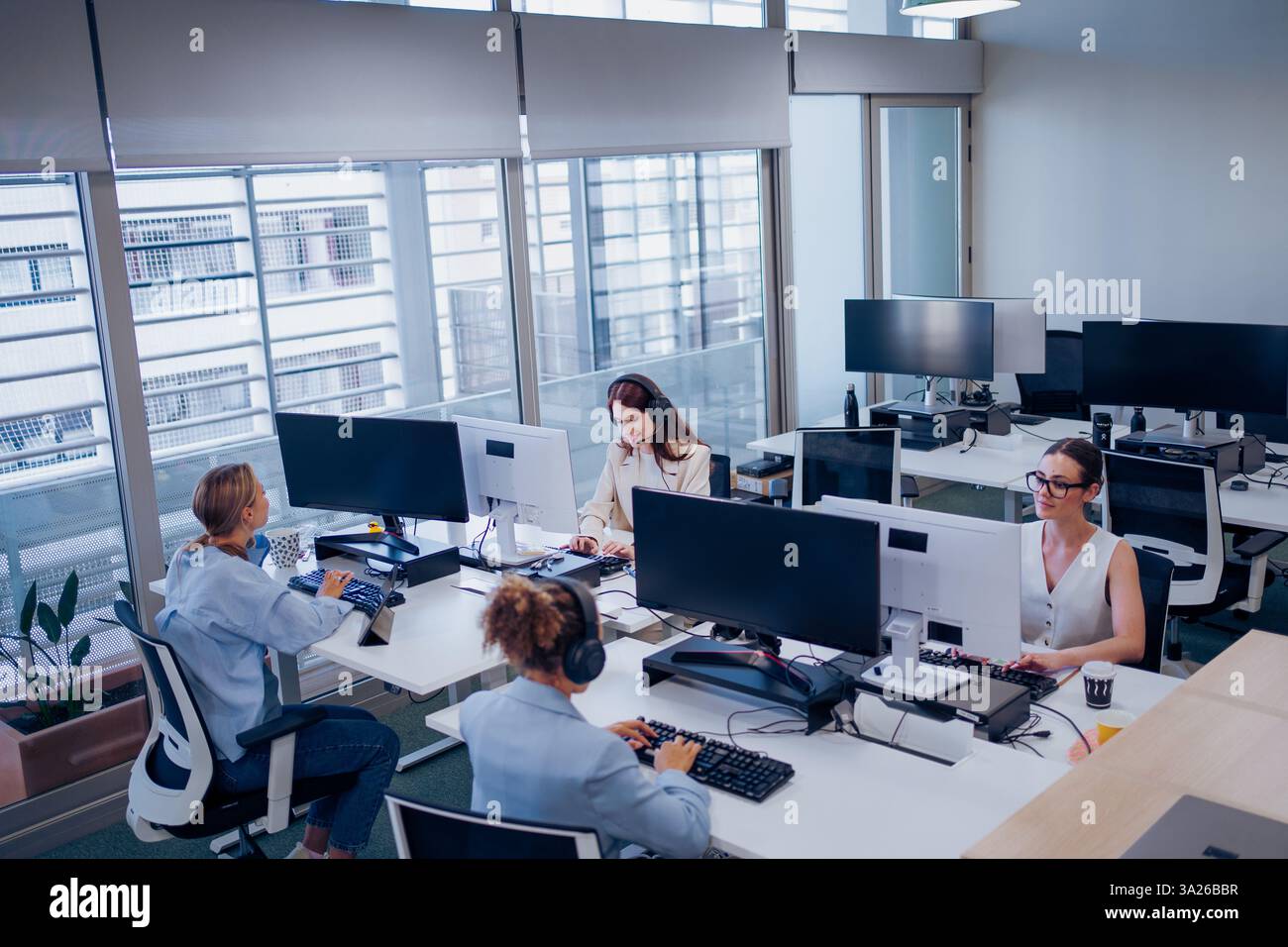 Modern Office Collaboration Features Professionals Actively Working at Their Desks Stock Photo