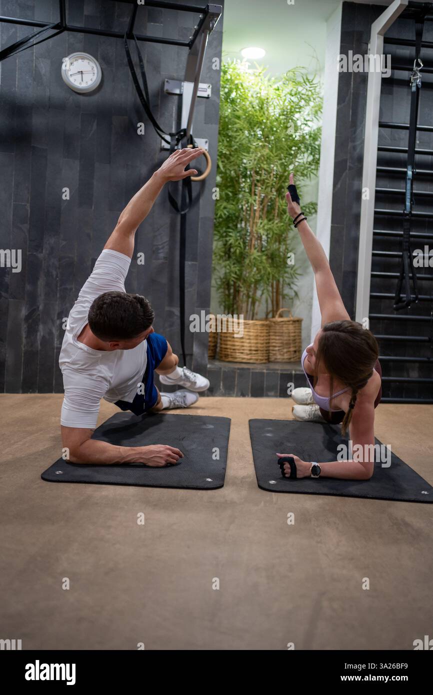 Optimistic young couple doing plank exercises and high five Stock Photo