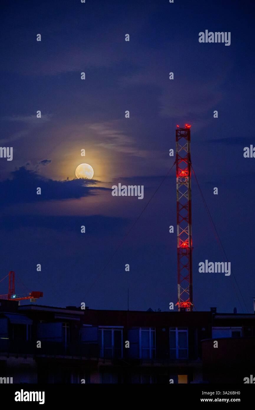 Lunar eclipse at dusk with transmission tower Stock Photo