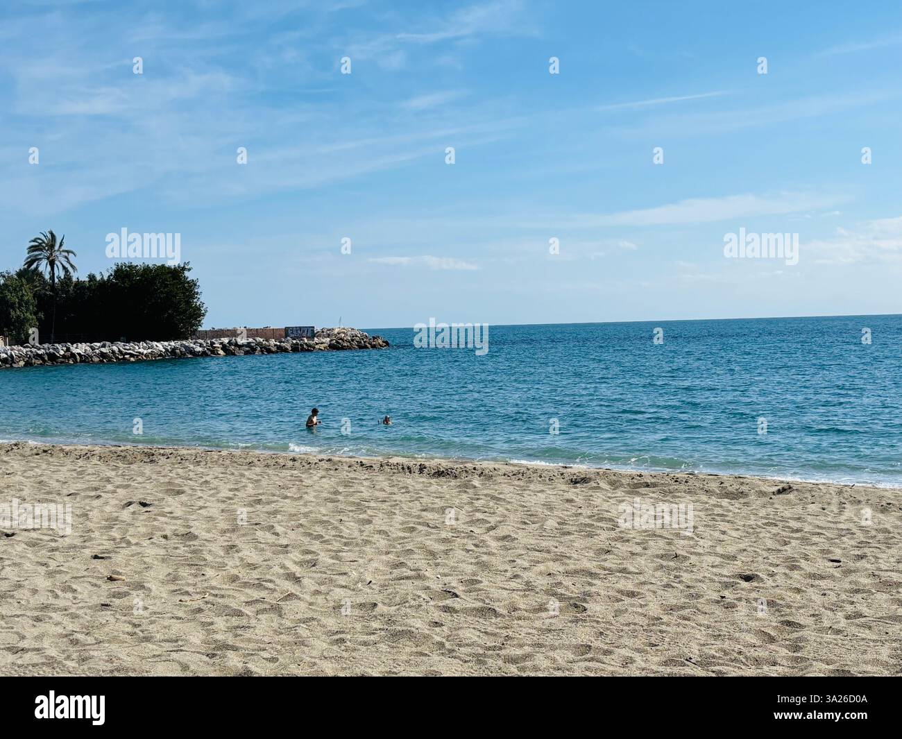 beach scene with 2 people in the water - Smartphone Captured Stock Image