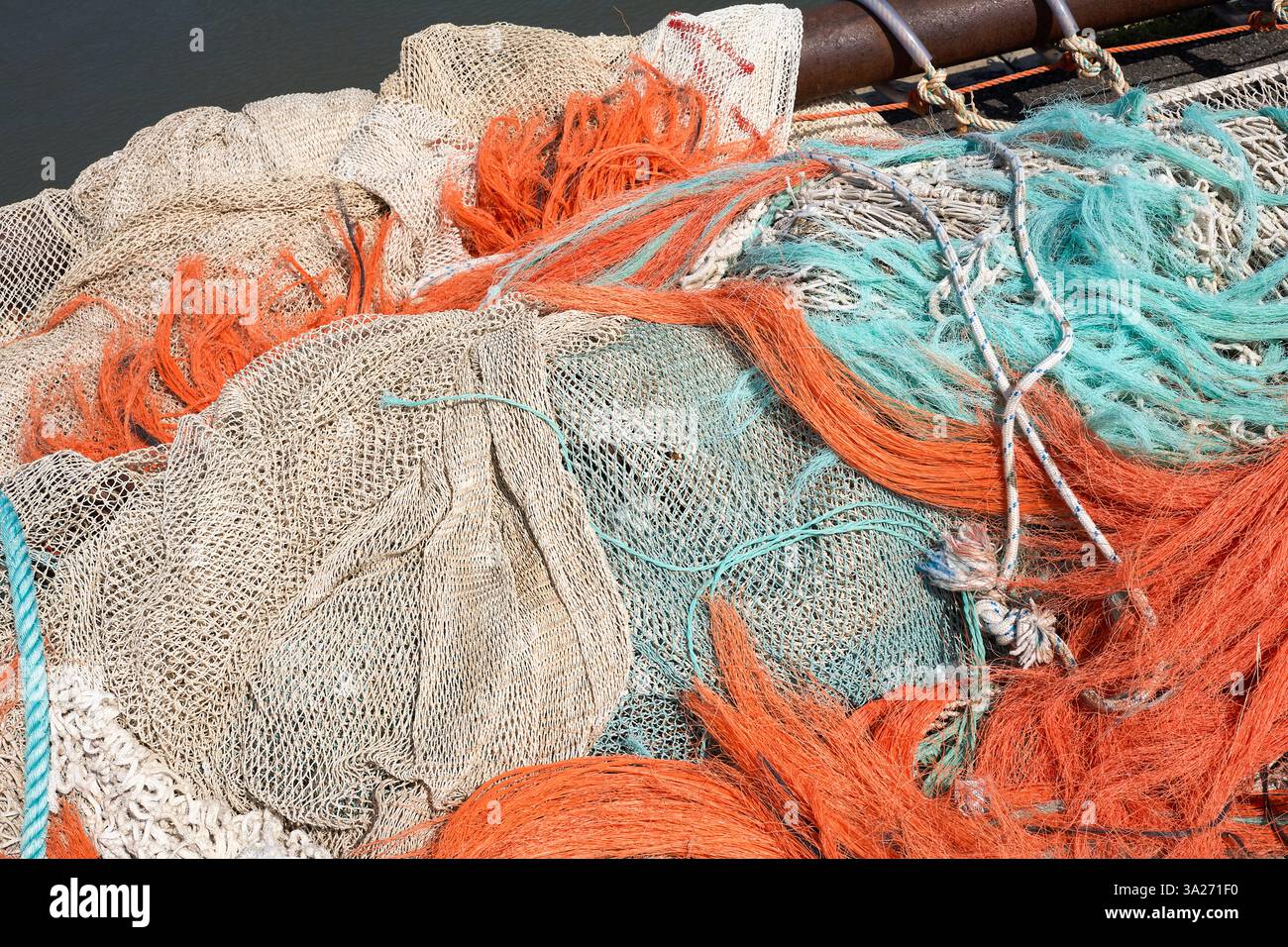 Colorful Rope Nets Colorful fishing nets and ropes piled on a boat deck under the sun ...
